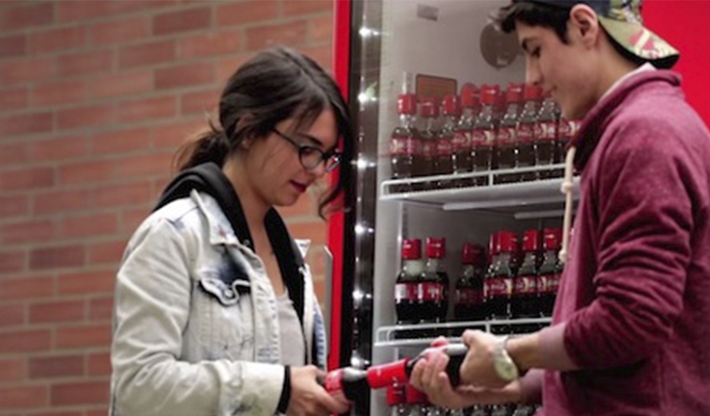 Una botella de Coca-Cola que requiere de dos personas para abrirse
